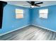 Light blue bedroom with wood-look floors and ceiling fan at 3148 Harvardston Loop, Holiday, FL 34691