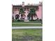 Pink building with arched walkways, palm trees, and lawn at 3148 Harvardston Loop, Holiday, FL 34691