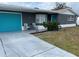 Gray house with teal garage door and small front yard at 3148 Harvardston Loop, Holiday, FL 34691