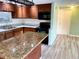 Kitchen with island, wood cabinets, and granite countertops at 3148 Harvardston Loop, Holiday, FL 34691