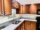 Kitchen with granite counters, wood cabinets, and double sink at 3148 Harvardston Loop, Holiday, FL 34691