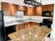 Kitchen with granite countertops, wood cabinets, and modern appliances at 3148 Harvardston Loop, Holiday, FL 34691