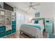 Bedroom with a queen bed, teal accents, and built-in shelving at 318 Windrush Blvd # 10, Indian Rocks Beach, FL 33785
