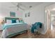 Bright bedroom with a queen bed, teal chair, and access to hallway at 318 Windrush Blvd # 10, Indian Rocks Beach, FL 33785