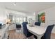Bright dining area with white table and blue chairs, overlooking living room and balcony at 318 Windrush Blvd # 10, Indian Rocks Beach, FL 33785