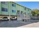 Two-story building with green exterior and covered parking at 318 Windrush Blvd # 10, Indian Rocks Beach, FL 33785