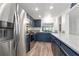 Modern kitchen with stainless steel appliances and navy blue cabinets at 318 Windrush Blvd # 10, Indian Rocks Beach, FL 33785