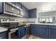 Modern kitchen with stainless steel appliances and navy blue cabinets at 318 Windrush Blvd # 10, Indian Rocks Beach, FL 33785