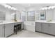 Spa-like bathroom with double vanities, soaking tub, and grey cabinetry at 32317 Rosewood Meadow Ln, Wesley Chapel, FL 33543