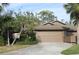 Tan colored exterior home with a two-car garage and manicured landscaping at 7108 Saint Andrews Ln, Sarasota, FL 34243