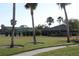 Landscaped lawn with palm trees and tennis courts at 7108 Saint Andrews Ln, Sarasota, FL 34243