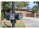 Two black mailboxes in front of a tan house with palm trees at 7108 Saint Andrews Ln, Sarasota, FL 34243