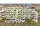 An aerial view of a light-green multi-story building with balconies and a pool at 11605 Gulf Blvd # 505, Treasure Island, FL 33706