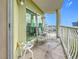 Private balcony with chairs and small table, overlooking the city at 11605 Gulf Blvd # 505, Treasure Island, FL 33706