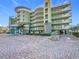 Contemporary building featuring multiple balconies and a paved courtyard at 11605 Gulf Blvd # 505, Treasure Island, FL 33706