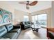 Living room with teal couches, ceiling fan, and ocean view at 11605 Gulf Blvd # 505, Treasure Island, FL 33706