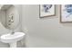 Small powder room with pedestal sink and framed art at 1508 Hammer Pl, Largo, FL 33774