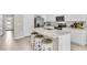 Modern kitchen with white cabinets, marble countertops, and stainless steel appliances at 1532 Hammer Pl, Largo, FL 33774