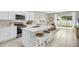 Modern kitchen with white cabinets, marble countertops, and stainless steel appliances at 1532 Hammer Pl, Largo, FL 33774