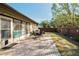 Enjoyable backyard patio with brick pavers, a table and chairs, and a partially fenced yard at 1597 Franklin Way, Dunedin, FL 34698