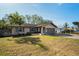 Tan house exterior with brown garage door and landscaped yard at 1597 Franklin Way, Dunedin, FL 34698