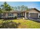 Single-story house with a landscaped yard and a two-car garage at 1597 Franklin Way, Dunedin, FL 34698