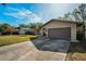 Tan house exterior with brown garage door and driveway at 1597 Franklin Way, Dunedin, FL 34698