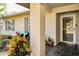 Inviting front entry with a covered porch, lush landscaping, and a charming door at 1597 Franklin Way, Dunedin, FL 34698
