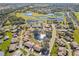Aerial view of a community with houses and a pond at 2243 Greenwich Dr, Sun City Center, FL 33573