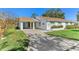White single story home with carport and mature landscaping at 2243 Greenwich Dr, Sun City Center, FL 33573