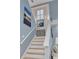 Stylish staircase with coastal-themed artwork and storage cabinet at 238 71St Ave, St Pete Beach, FL 33706