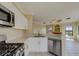Kitchen with stainless steel appliances and white cabinets, open to living area at 2741 Via Cipriani # 930A, Clearwater, FL 33764