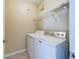 Well-lit laundry room with washer, dryer, and shelving at 2741 Via Cipriani # 930A, Clearwater, FL 33764