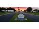 Mainlands Unit 6 entrance with landscaped street and signage at sunset at 3562 90Th N Ter, Pinellas Park, FL 33782