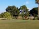 Landscaped golf course putting green with trees and shrubs at 3562 90Th N Ter, Pinellas Park, FL 33782