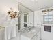 Bright bathroom, marble vanity, large mirror, and elegant light fixture at 5200 Brittany S Dr # 1110, St Petersburg, FL 33715
