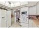 White kitchen with pink tile, stainless steel appliances, and ample counter space at 5200 Brittany S Dr # 1110, St Petersburg, FL 33715