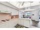 Bright kitchen with white cabinets, pink tile, and modern appliances at 5200 Brittany S Dr # 1110, St Petersburg, FL 33715