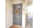 Gray front door with a gold wreath, showcasing the entrance to the condo at 6104 Palma Del Mar S Blvd # 104, St Petersburg, FL 33715