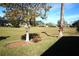 View of grassy backyard with trees and distant homes at 11021 Edge Park Dr, Hudson, FL 34667