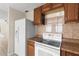 Kitchen with wooden cabinets, white appliances, and granite countertops at 1310 Preston S St, St Petersburg, FL 33712