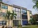 Condo building showcasing large windows and a well-maintained lawn at 14130 Rosemary Ln # 6214, Largo, FL 33774