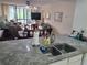 Kitchen with granite counters, double sink, living room view at 14130 Rosemary Ln # 6214, Largo, FL 33774