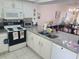 Bright kitchen, granite counters, white cabinets, and stainless steel appliances at 14130 Rosemary Ln # 6214, Largo, FL 33774