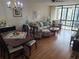 Spacious living area with hardwood floors, a dining set, and access to a screened balcony at 14130 Rosemary Ln # 6214, Largo, FL 33774