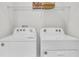 Bright laundry room with washer and dryer and overhead shelving at 1540 Hammer Pl, Largo, FL 33774