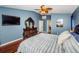 Main bedroom with hardwood floors, large TV, and ensuite bathroom access at 15815 Muirfield Dr, Odessa, FL 33556