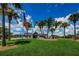 Community clubhouse with a flag and palm trees in front at 15815 Muirfield Dr, Odessa, FL 33556
