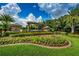 Gated community entrance with landscaping and a pond at 15815 Muirfield Dr, Odessa, FL 33556