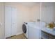 Bright laundry room with washer, dryer, and storage at 15815 Muirfield Dr, Odessa, FL 33556